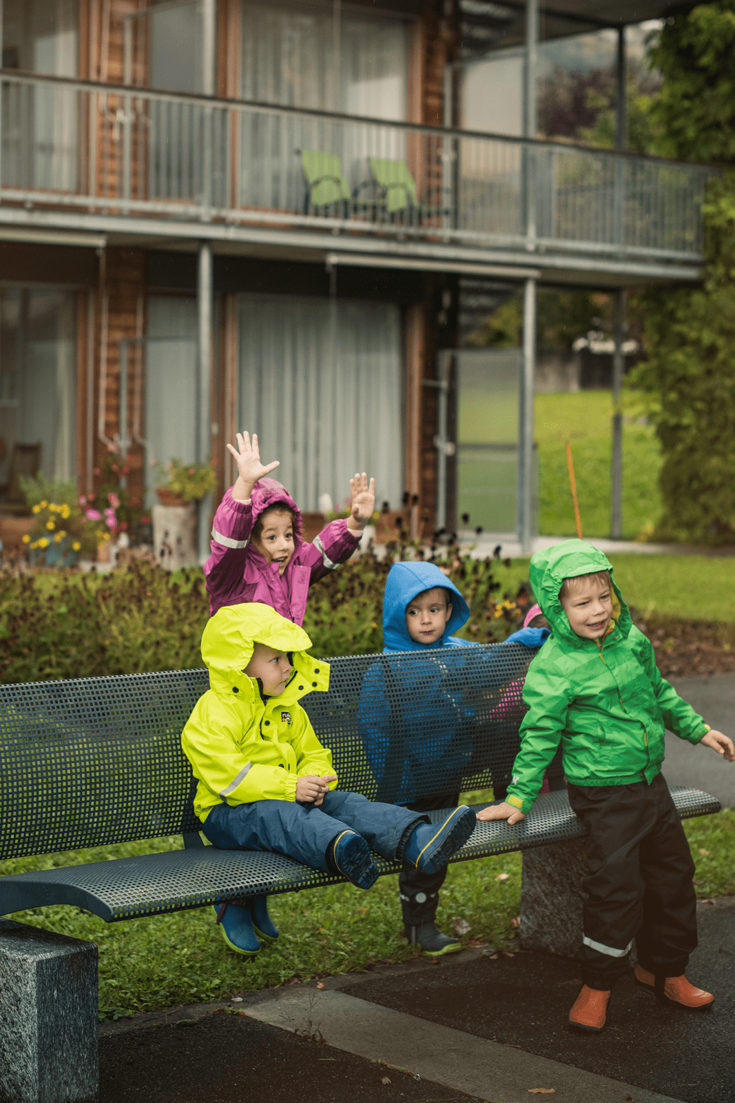 Kita-Kinder haben trotz Regenwetter draussen gute Laune beim Spielen.