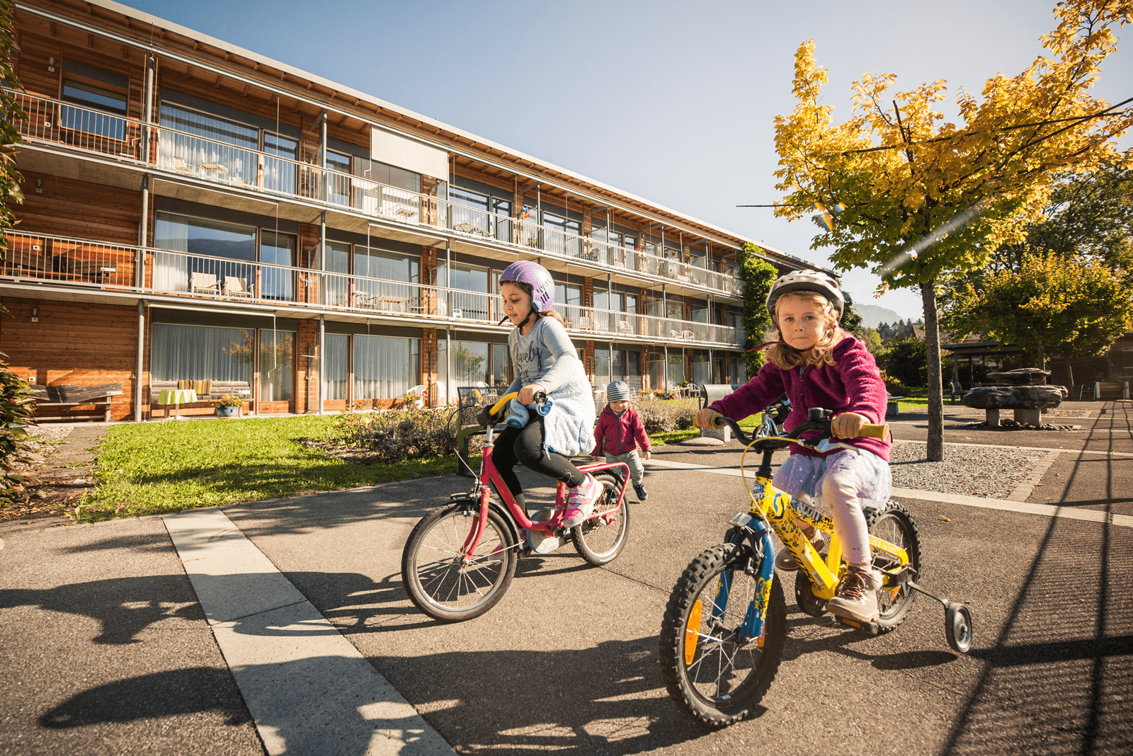Mädchen fahren draussen Fahrrad.